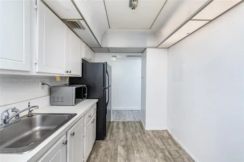 a kitchen with granite countertop a stove and cabinets
