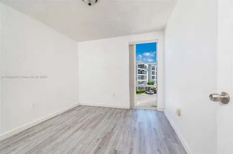 an empty room with wooden floor and mirror