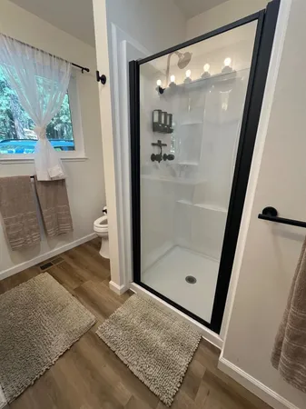 a bathroom with a glass door shower and toilet