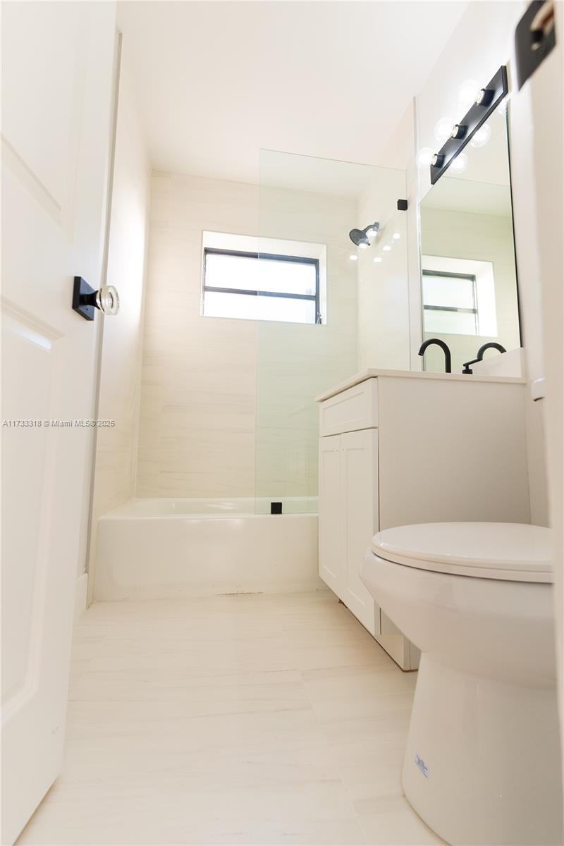 Westchester Miami, FL 33155 - Photo 14 of 17 a bathroom with a granite countertop sink a toilet and shower