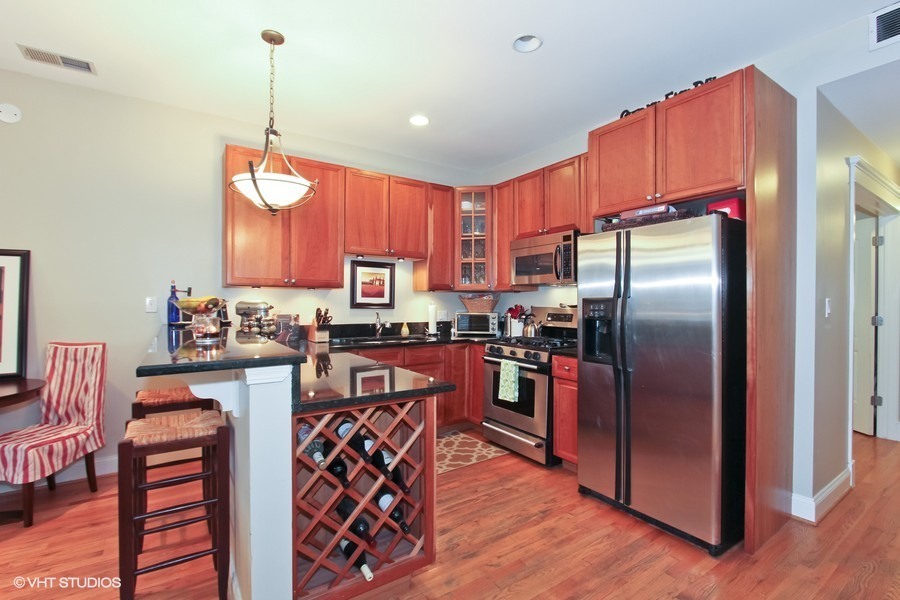 1939 West Division Street, Unit R2 Chicago, IL 60622 - Photo 3 of 9 a kitchen with stainless steel appliances granite countertop a refrigerator a sink dishwasher a stove and a dining table with wooden floor