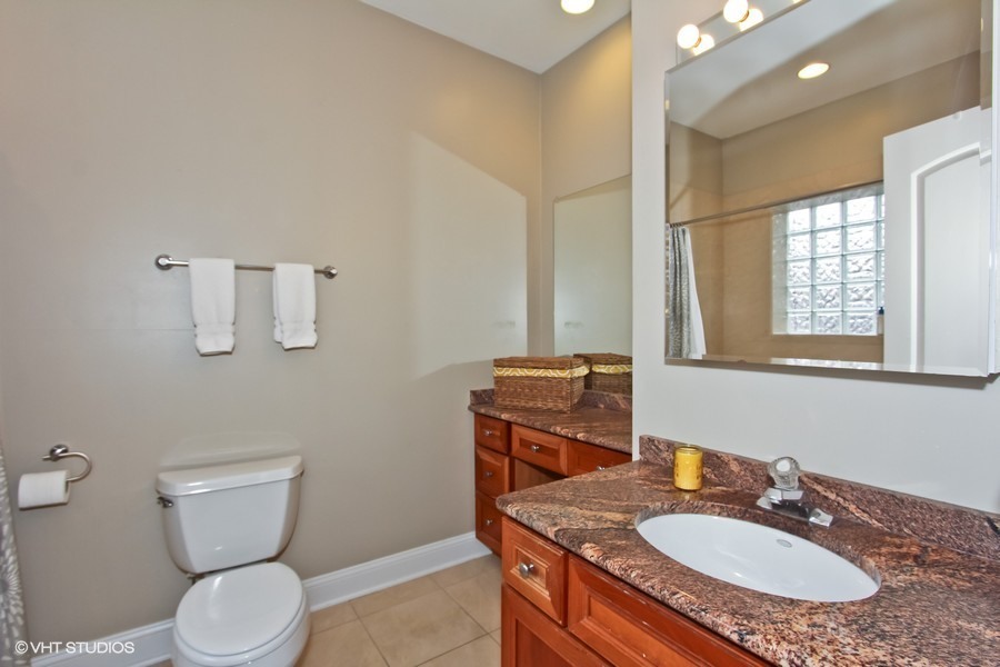 1939 West Division Street, Unit R2 Chicago, IL 60622 - Photo 6 of 9 a bathroom with a granite countertop toilet sink and mirror
