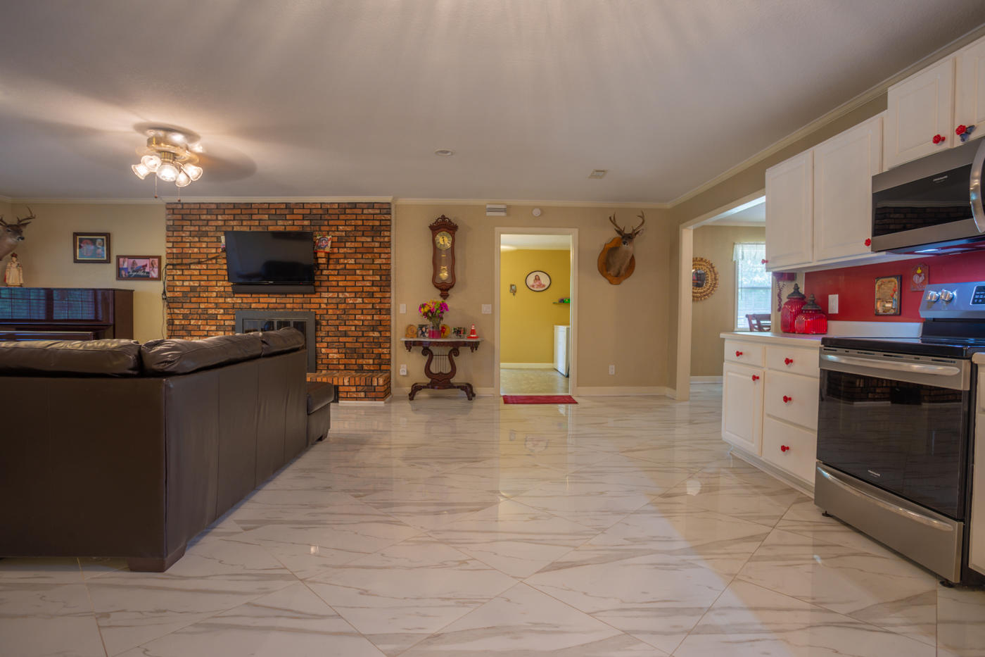 5621 Buckward Road Baker, FL 32531 - Photo 11 of 41 a living room with stainless steel appliances furniture a fireplace and a flat screen tv