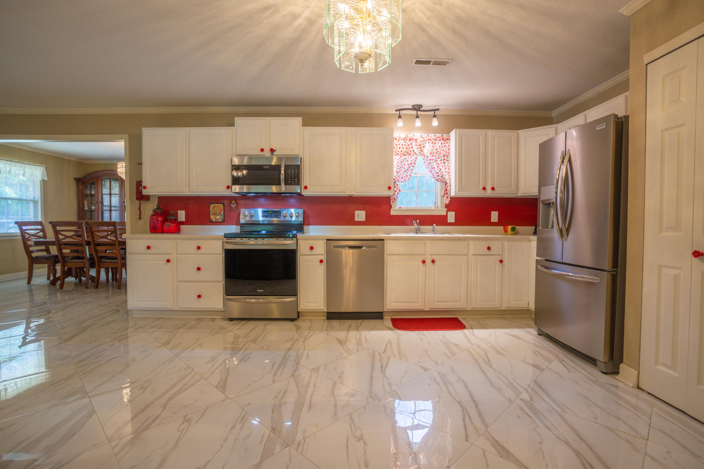 5621 Buckward Road Baker, FL 32531 - Photo 10 of 41 a kitchen with stainless steel appliances granite countertop a refrigerator a sink dishwasher a stove and a dining table with wooden floor