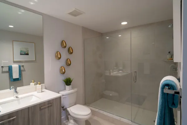 a bathroom with a sink a toilet and shower