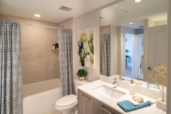 a bathroom with a granite countertop sink toilet and shower