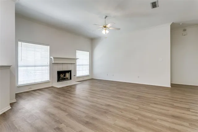 a view of a livingroom with a fireplace wooden floor and windows