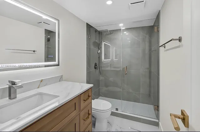 a bathroom with a sink a toilet and shower