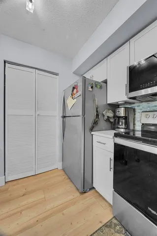 a kitchen with a refrigerator and a stove top oven