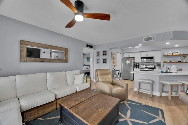 a living room with furniture and a view of kitchen