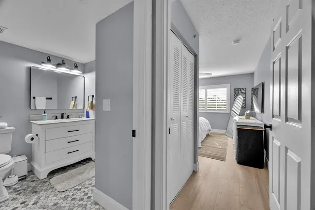 a view of a hallway with bathroom and mirror