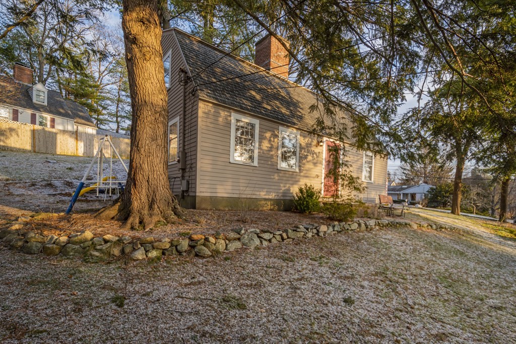 1 Constitution Road Lexington, MA 02421 - Photo 32 of 42 a backyard of a house with large trees and outdoor seating