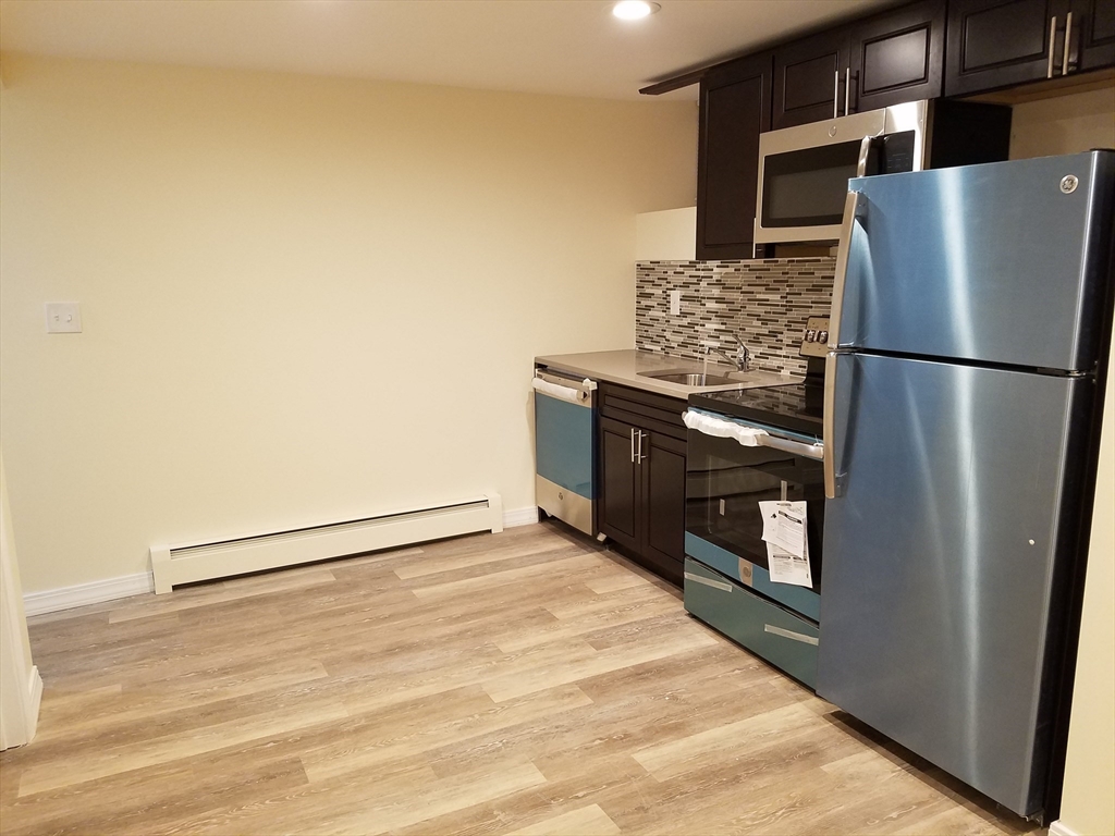 98 Topliff Street Boston, MA 02122 - Photo 13 of 15 a kitchen with stainless steel appliances a refrigerator and a stove