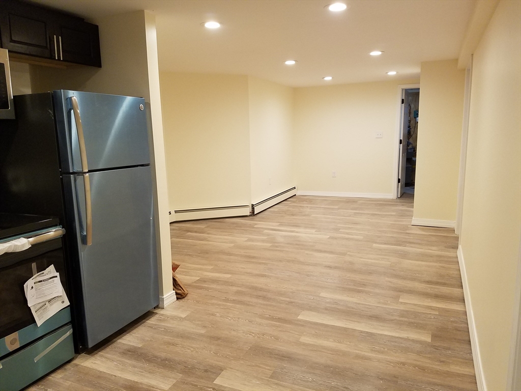 98 Topliff Street Boston, MA 02122 - Photo 14 of 15 a view of a refrigerator in kitchen and an empty room