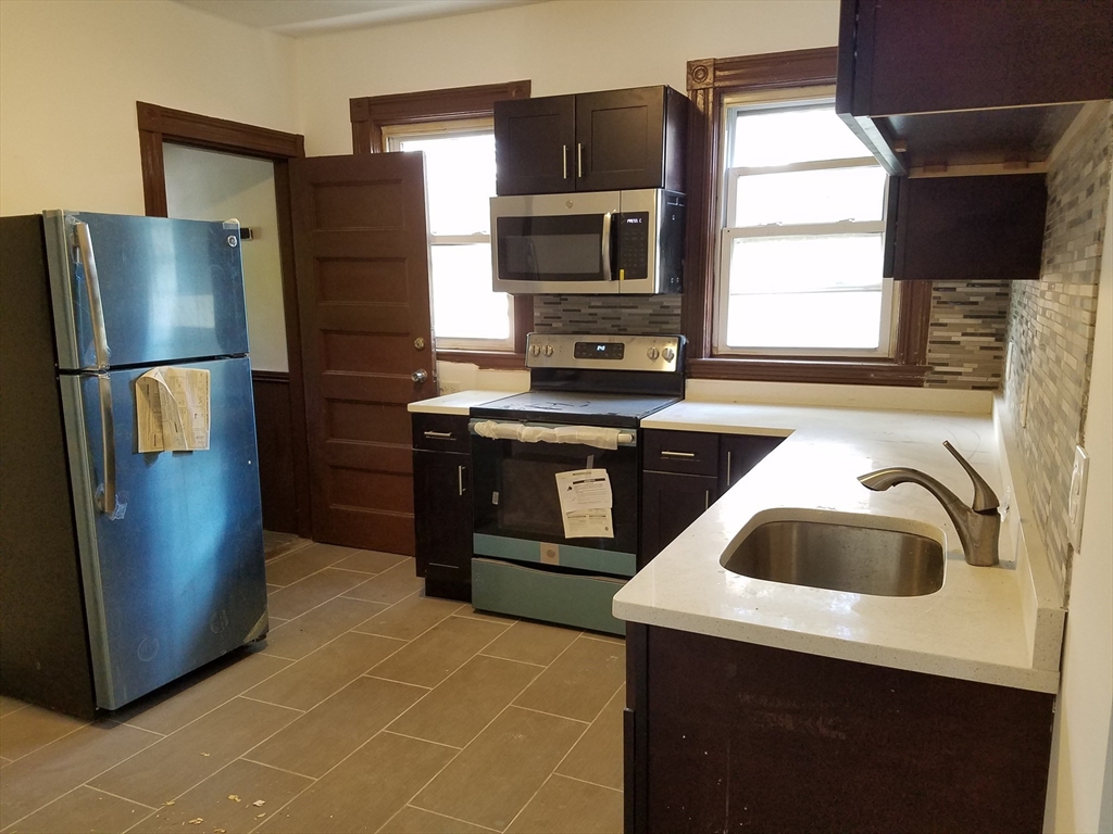 98 Topliff Street Boston, MA 02122 - Photo 3 of 15 a kitchen with stainless steel appliances a stove a refrigerator and a sink