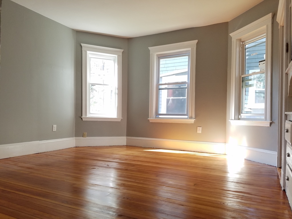 98 Topliff Street Boston, MA 02122 - Photo 5 of 15 a view of an empty room with wooden floor and a window