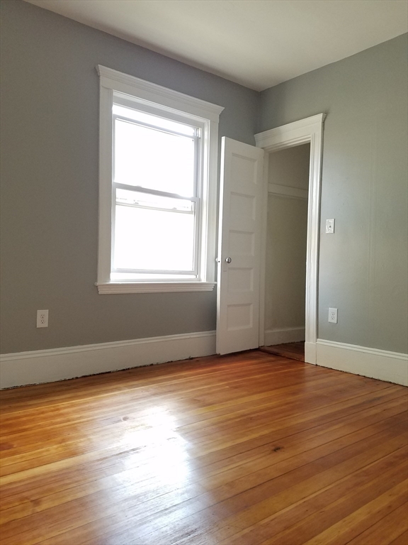 98 Topliff Street Boston, MA 02122 - Photo 7 of 15 an empty room with wooden floor and windows