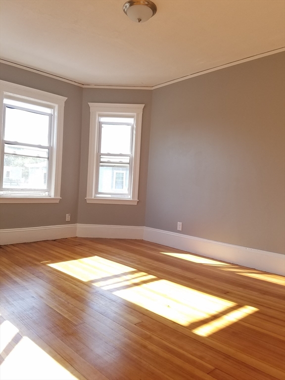 98 Topliff Street Boston, MA 02122 - Photo 9 of 15 a view of empty room with wooden floor and fan