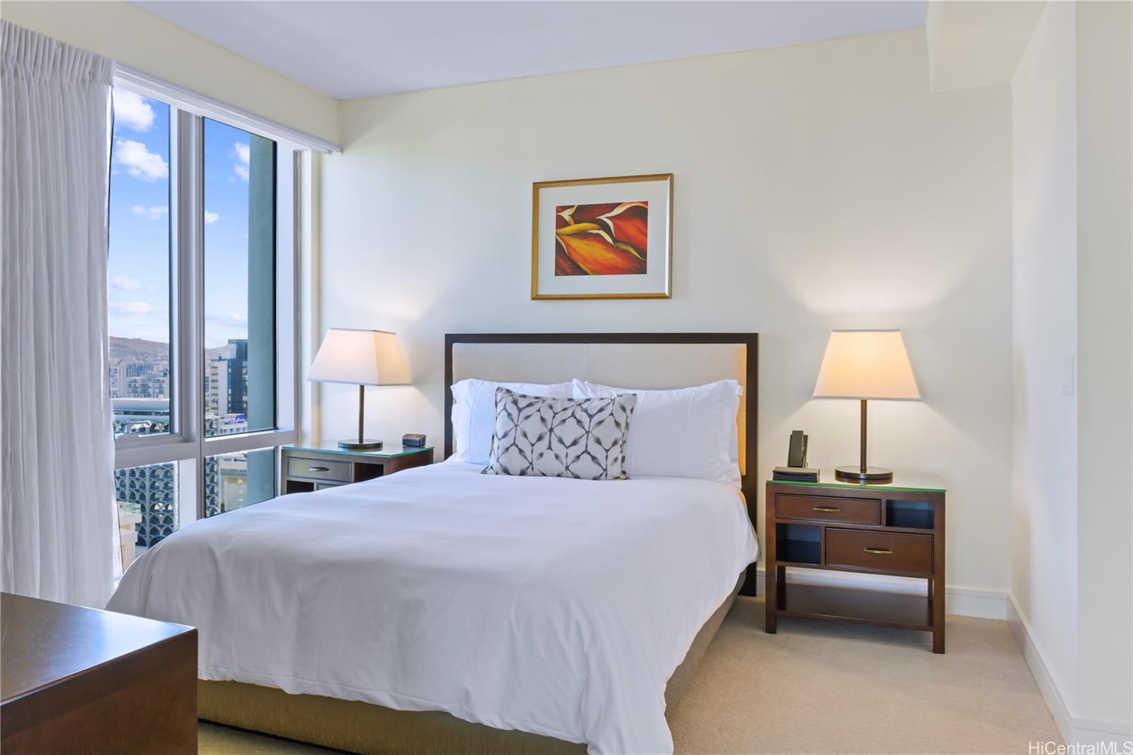 223 Saratoga Road, Unit 2601 Honolulu, HI 96815 - Photo 20 of 23 a bedroom with a bed and a lamp