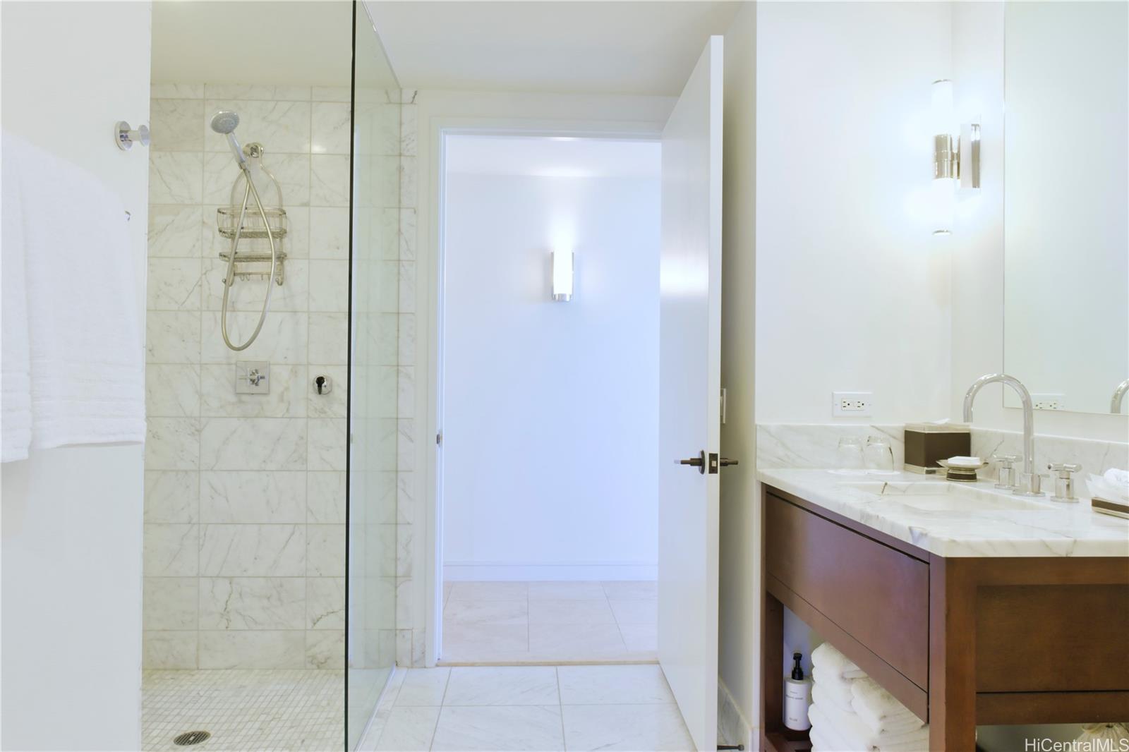223 Saratoga Road, Unit 2601 Honolulu, HI 96815 - Photo 21 of 23 a bathroom with a granite countertop shower sink and mirror