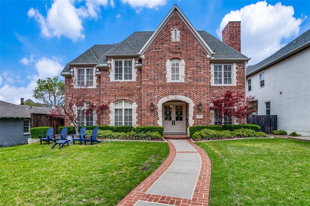a front view of a house with a yard and potted plants