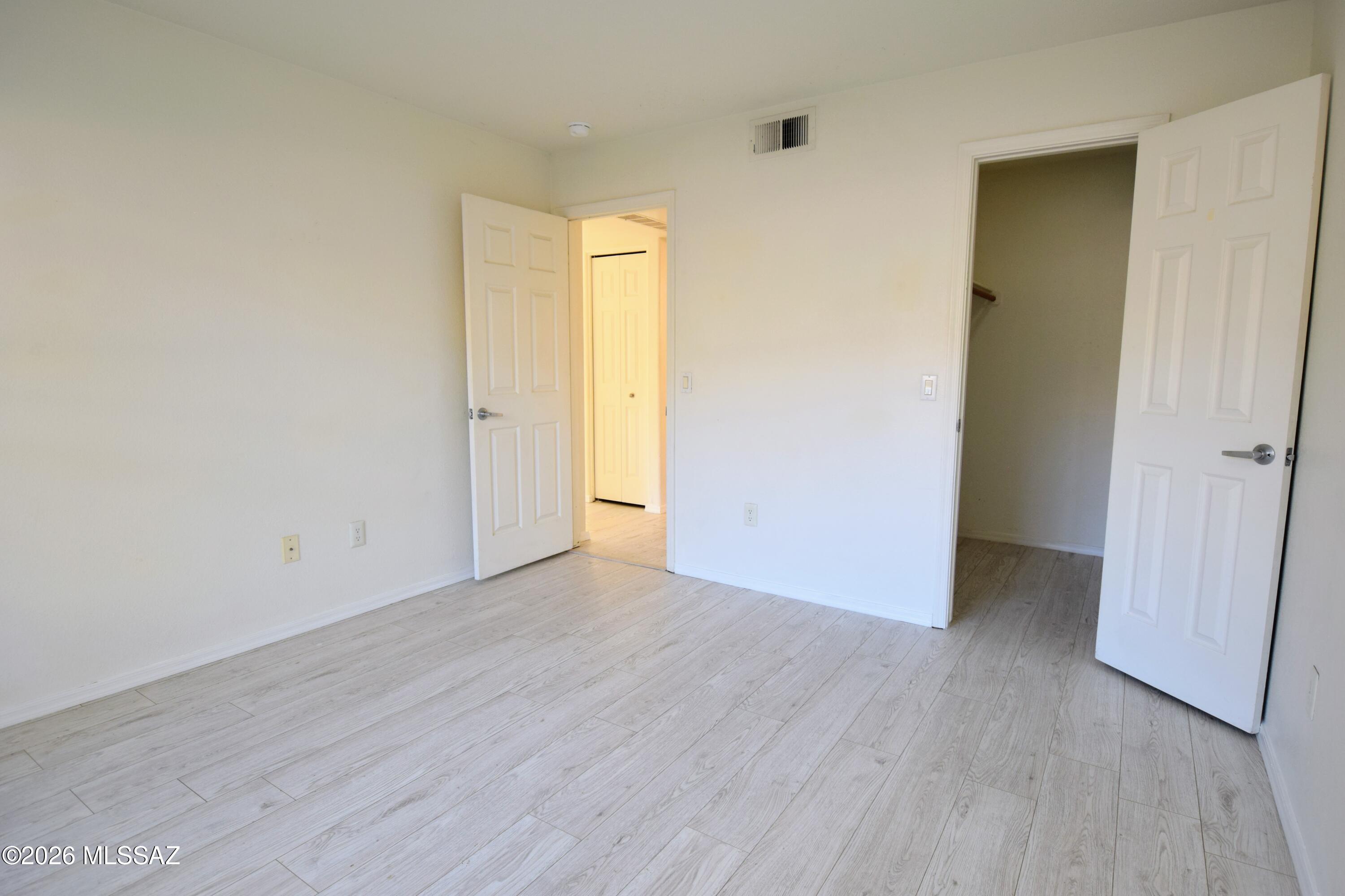 5855 North Kolb Road, Unit 11106 Tucson, AZ 85750 - Photo 18 of 36 an empty room with wooden floor and a hallway