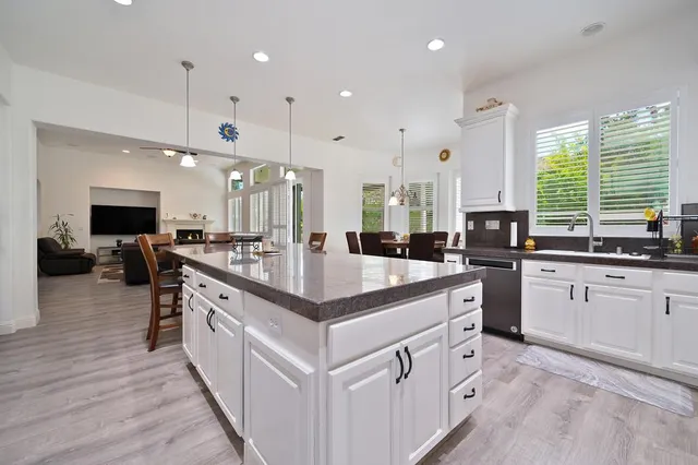 a large kitchen with stainless steel appliances kitchen island granite countertop a large island in the center