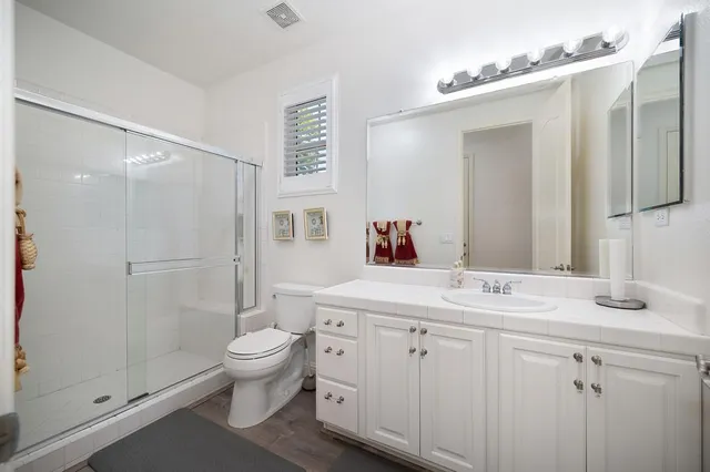 a bathroom with a sink a toilet and shower