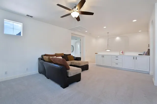 a living room with furniture and a ceiling fan