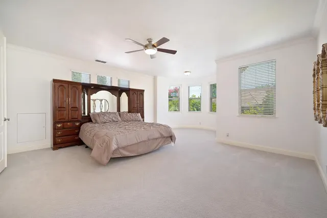 a spacious bedroom with a large bed and a chandelier