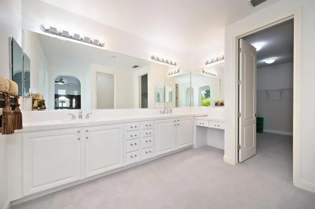 a spacious bathroom with a double vanity sink a mirror and a bathtub