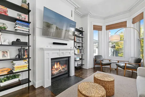 a living room with furniture fireplace and window