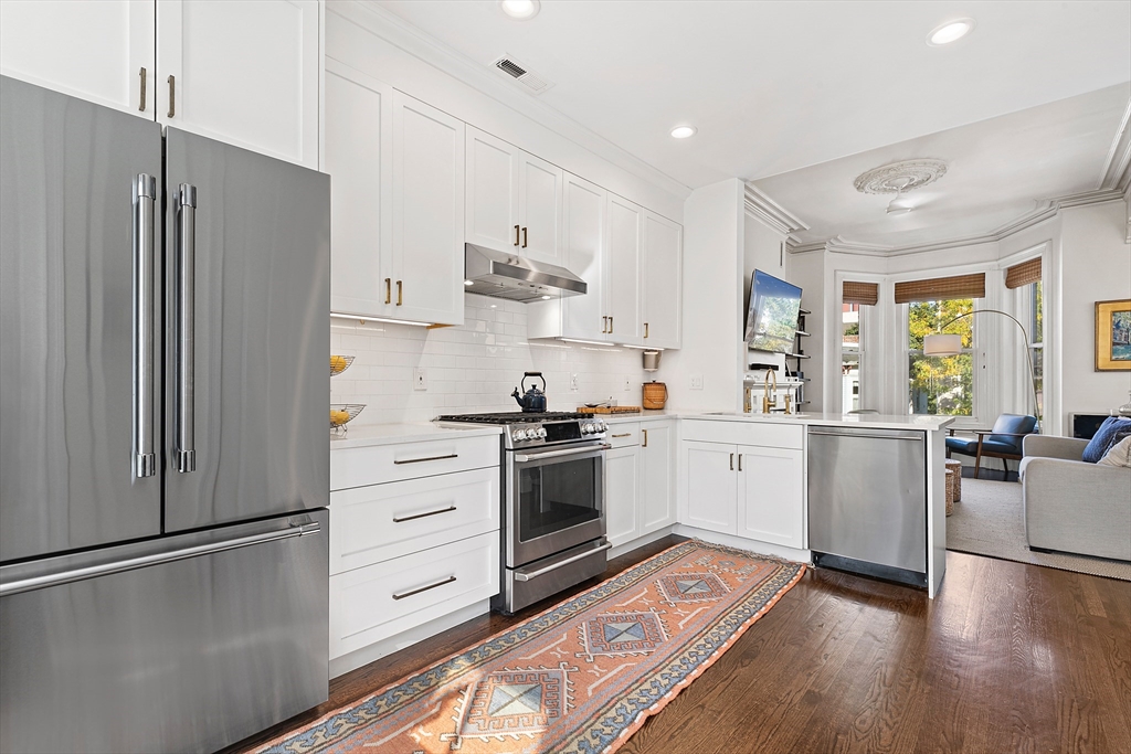 649 East 3rd Street, Unit 2 Boston, MA 02127 - Photo 6 of 16 a kitchen with a refrigerator stove and wooden floor