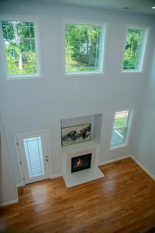 a view of empty room with wooden floor and windows