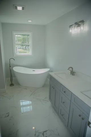 a spacious bathroom with a toilet a sink a mirror and a window