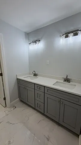a bathroom with a double vanity sink and a mirror