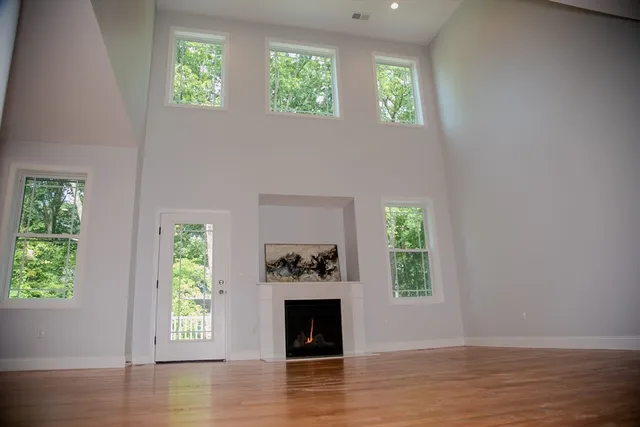 an empty room with windows and fireplace
