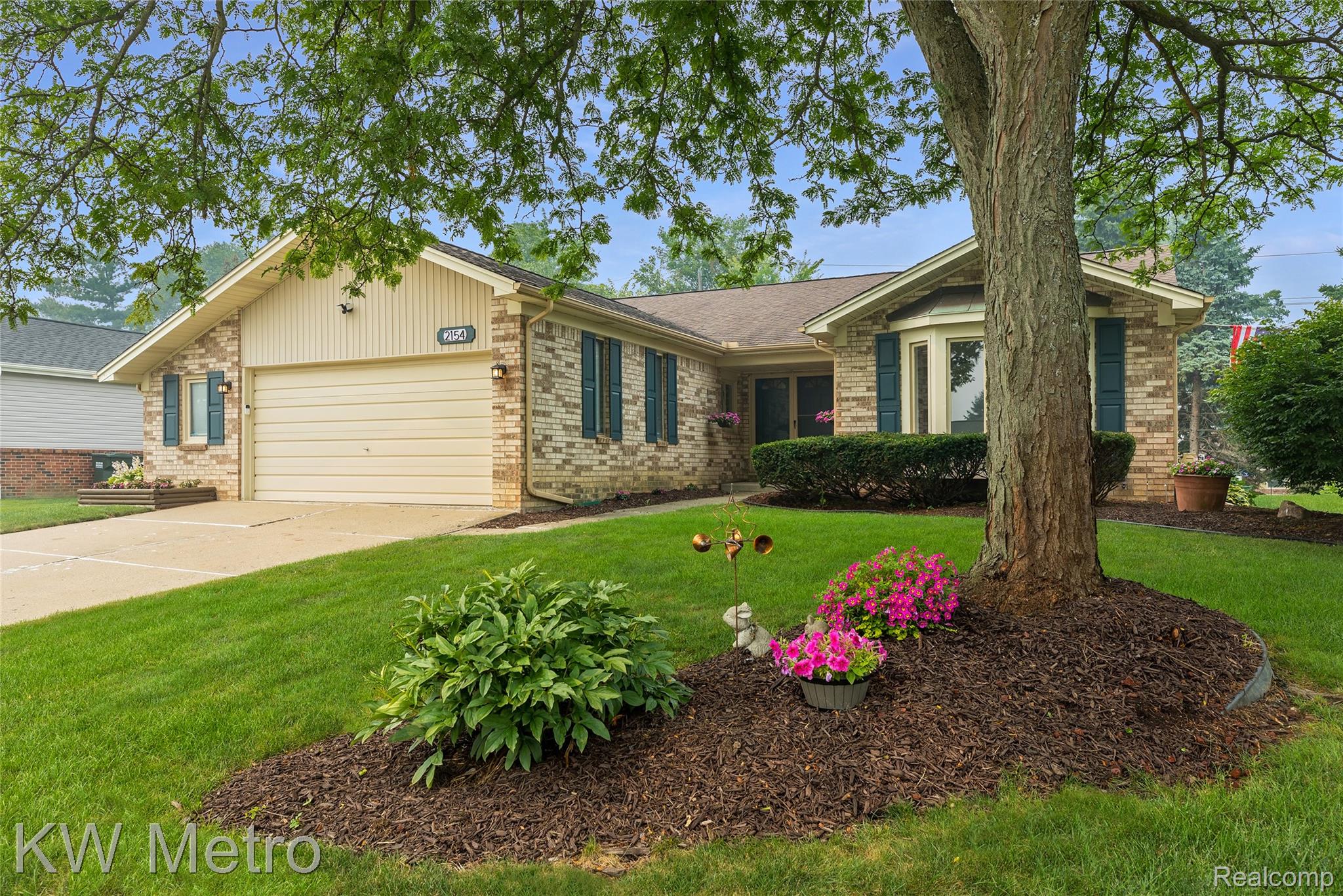 2154 Warrington Road Rochester, MI 48307 - Photo 1 of 41 Brick facade residence featuring an attached garage, bay window, landscaped front yard, and mature trees