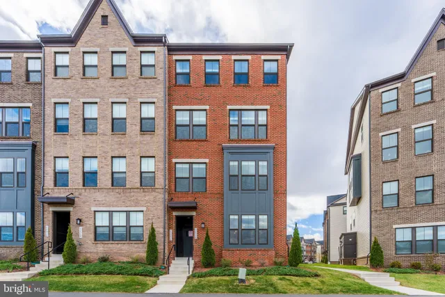 a front view of a building with yard and traffic signal
