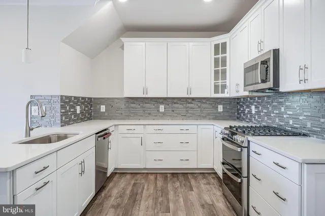 a kitchen with white cabinets sink and stove