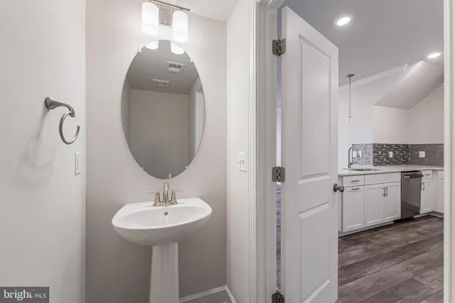 a bathroom with a sink a light fixture and a mirror