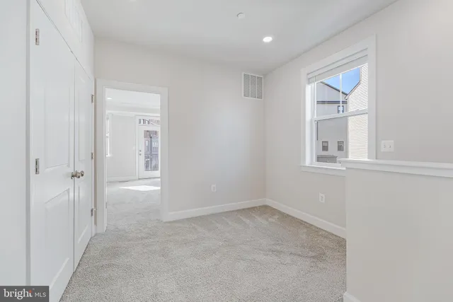 an empty room with windows and closet