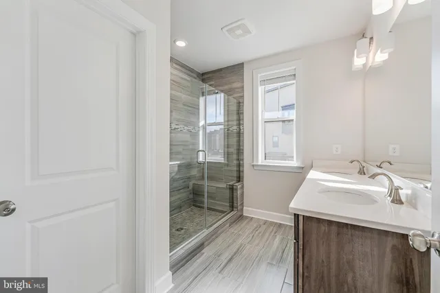 a bathroom with a sink mirror and shower