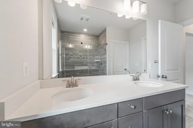 a bathroom with a sink double vanity and a shower