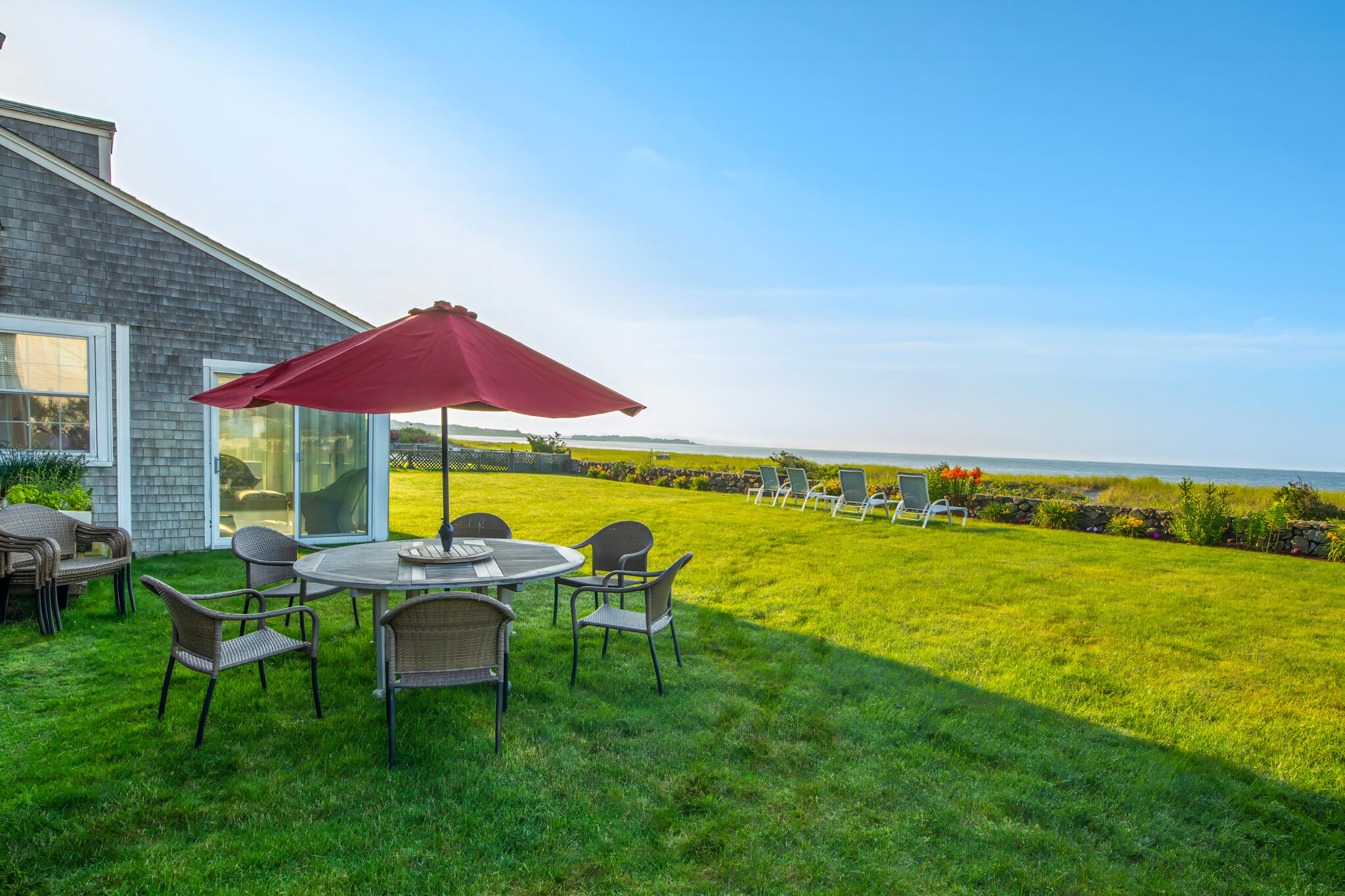 103 Long Beach Road Centerville, MA 02632 - Photo 10 of 36 a view of a patio with chairs under an umbrella