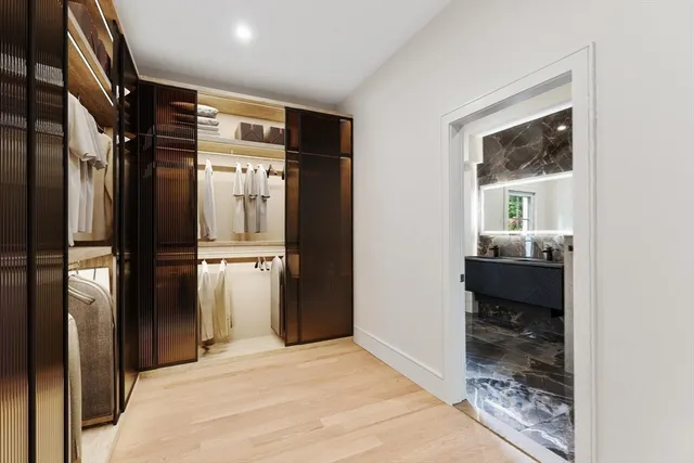 a view of a hallway with wooden floor and a living room