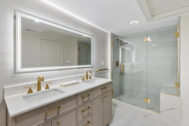 a bathroom with a shower sink double vanity and mirror