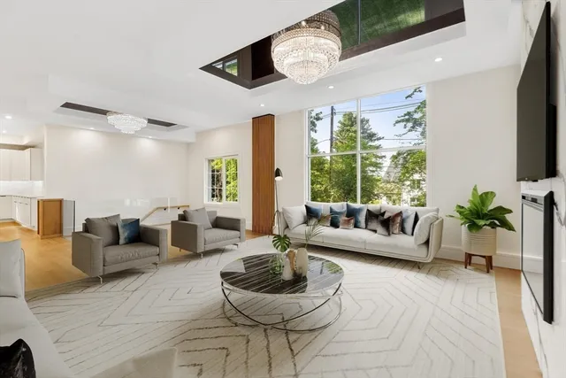 a living room with furniture a flat screen tv and a large window