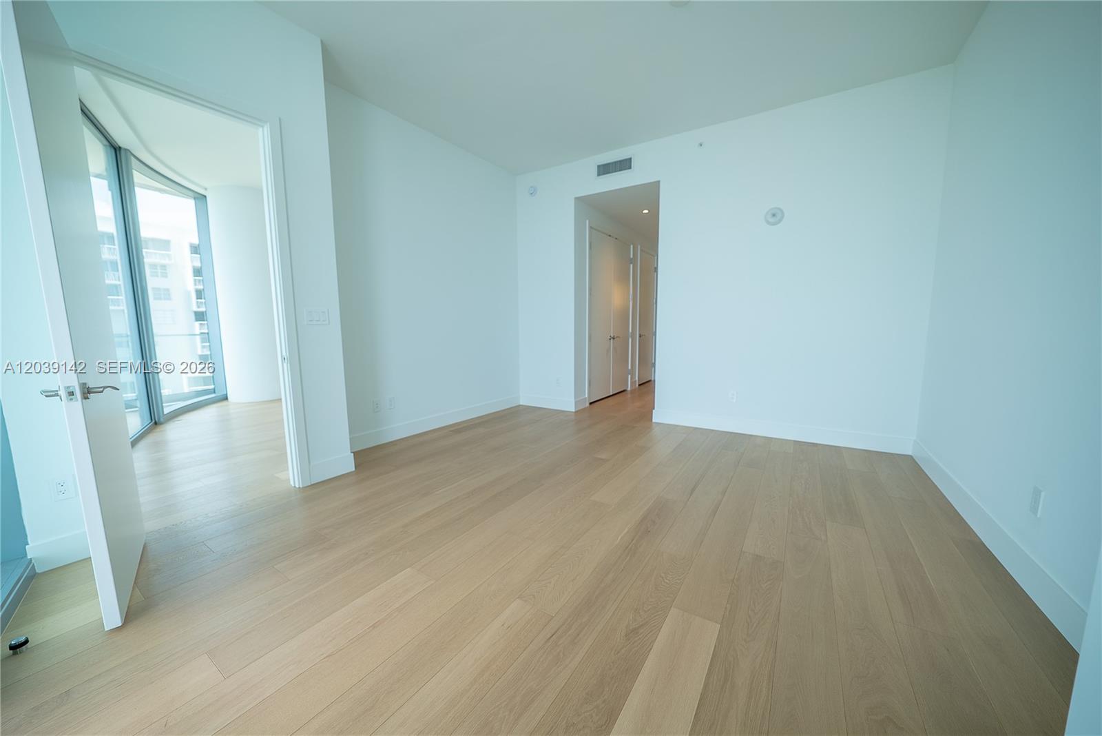 175 Southeast 25th Road, Unit 702 Miami, FL 33129 - Photo 4 of 30 a view of an empty room with wooden floor and a window
