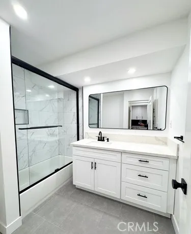 a bathroom with a double vanity sink mirror and bathtub
